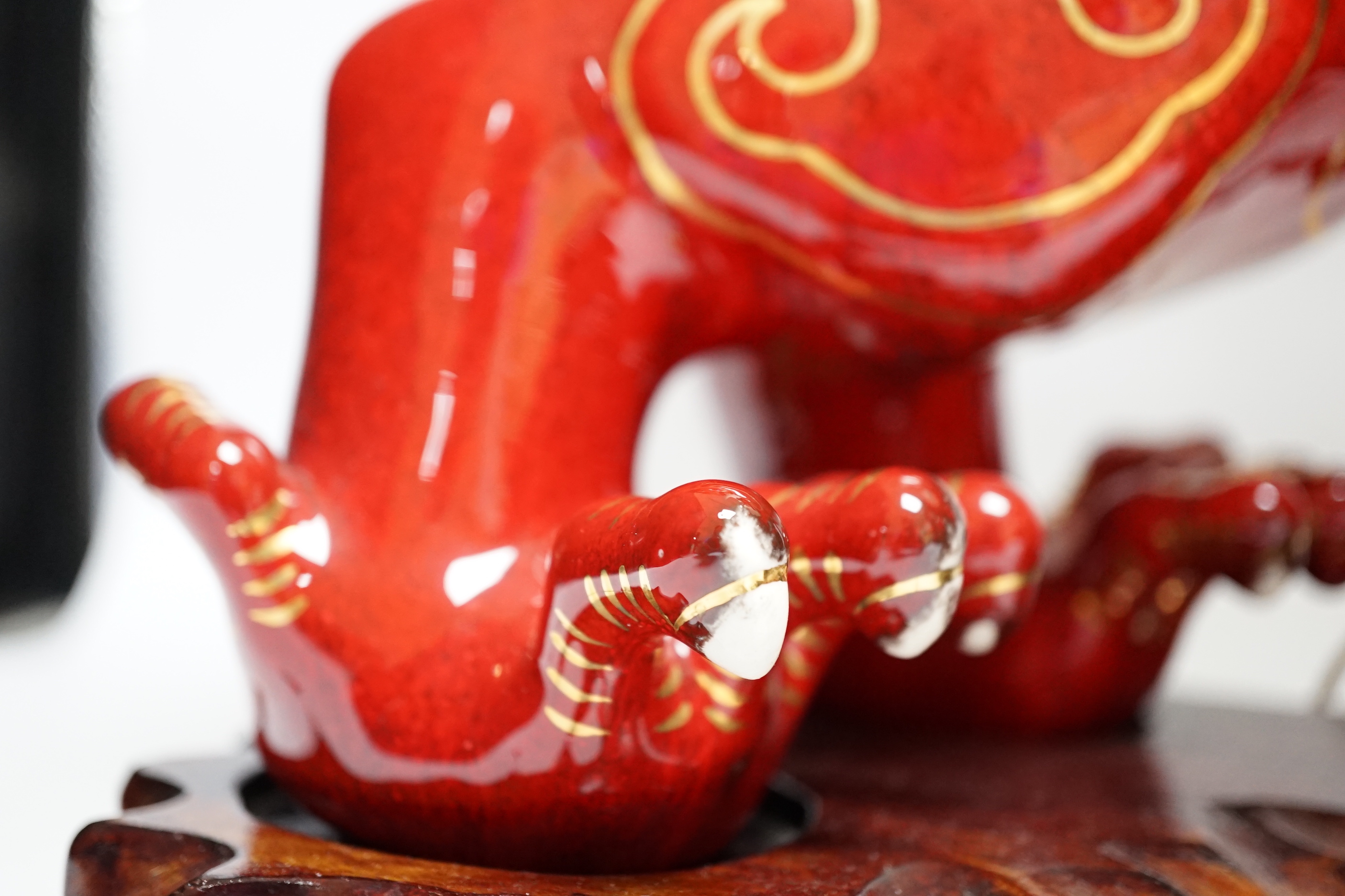 A modern Chinese red and gilt glazed ceramic 'dragon' table lamp on carved wood stand with shade, total height 68cm